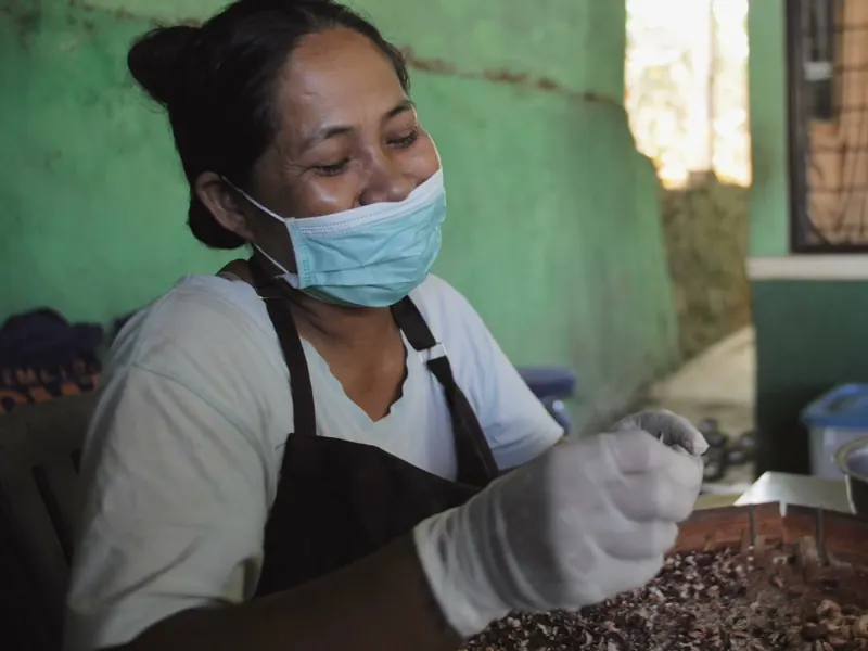 A worker shelling cashews by hand